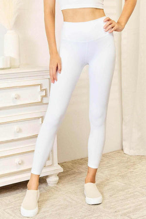 Woman wearing white Double Take Wide Waistband sports leggings with a supportive high-rise waistband