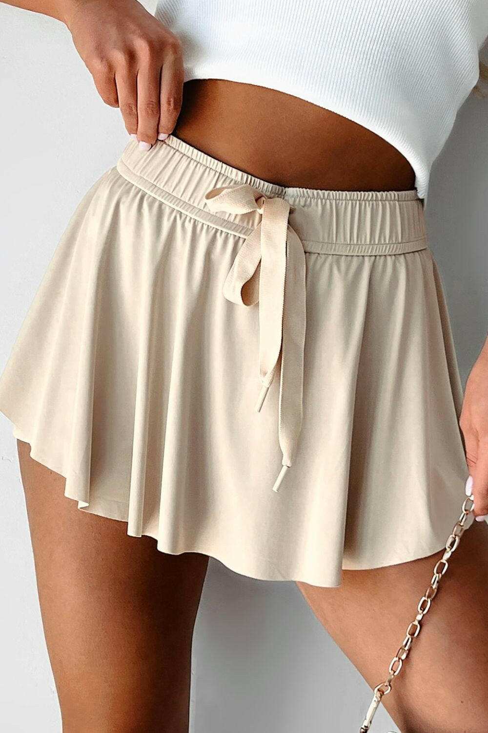 Beige drawstring high waist lined active skorts with moderate stretch and flowy design