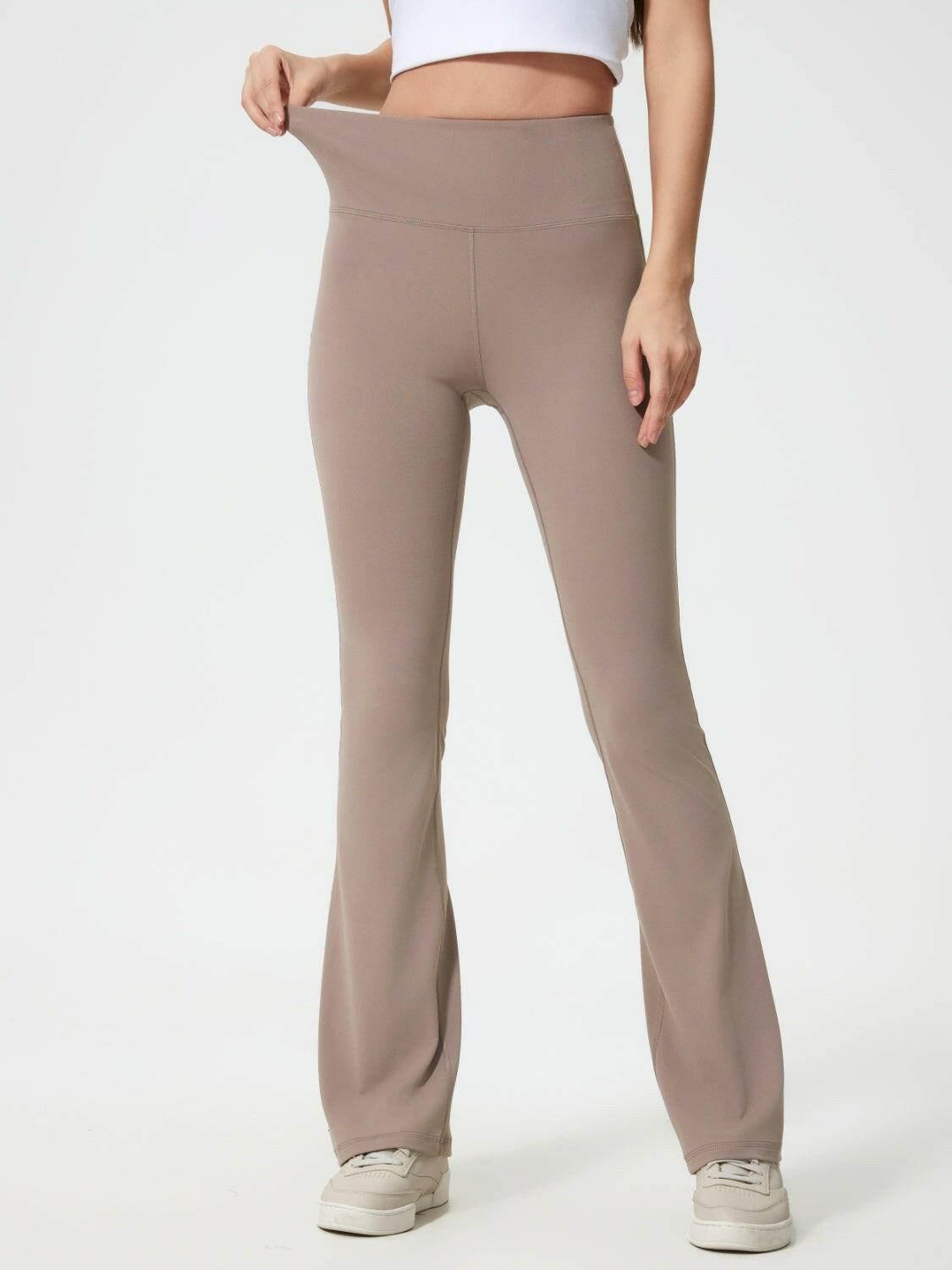 Stretchy taupe Millennia High Waist active pants with flared legs worn by a slim model