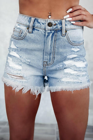 Distressed raw hem high waist denim shorts with frayed edges and ripped details in light blue wash