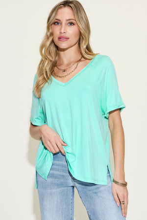Woman wearing a mint green Basic Bae Full Size bamboo V-neck short sleeve t-shirt with side slits and light stretch.