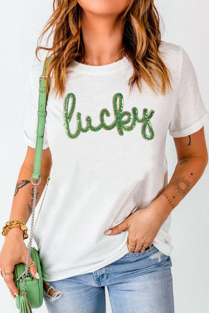 White Sequined Lucky St.Patricks Day T-Shirt with green sequin lettering and short sleeves, styled with denim shorts and green purse.