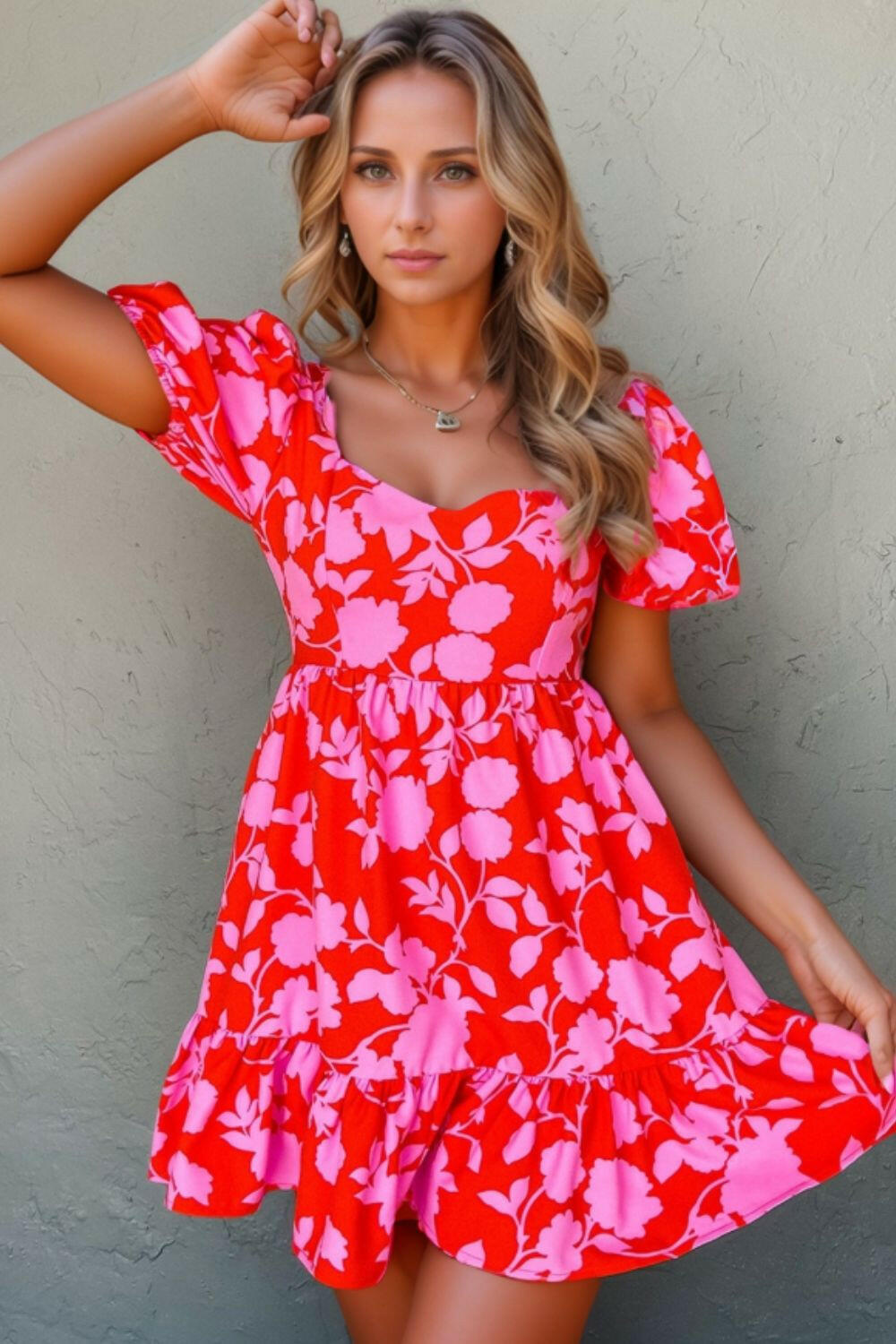 Woman wearing a red floral puff sleeve sweetheart neck ruffled mini dress