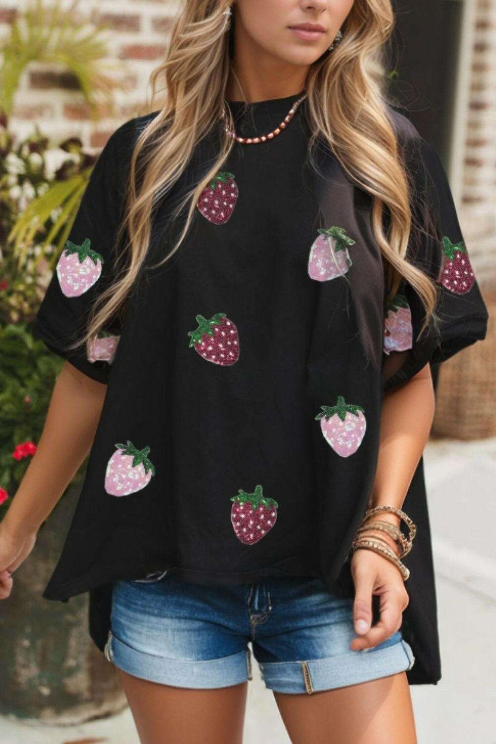 Black sequin strawberry high low half sleeve relaxed fit t-shirt with pink and red strawberry designs.