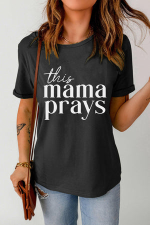 Black THIS MAMA PRAYS Graphic Tee with short sleeves and round neck worn with jeans and brown purse