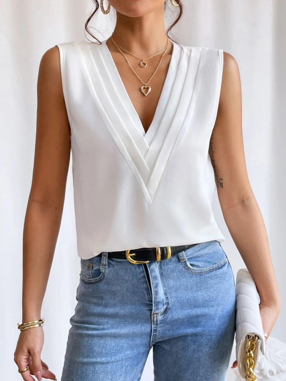 White V-Neck pleated sleeveless cami tank top paired with blue jeans and gold accessories